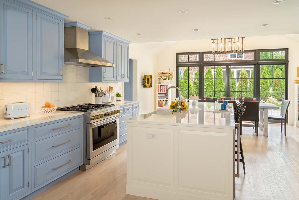 Benjamin Moore Sunrise is a trendy blue gray paint colors for cabinets in a kitchen pictured here with a contrasting white island